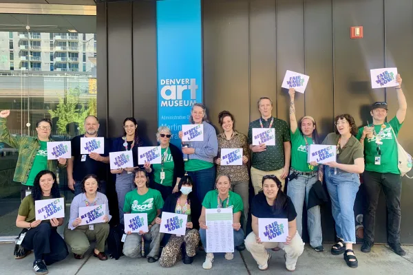 DAMWU workers stand outside of the Denver Art Museum holding signs to celebrate their win